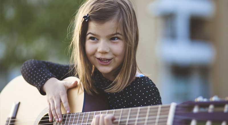 Young girl strumming the guitar