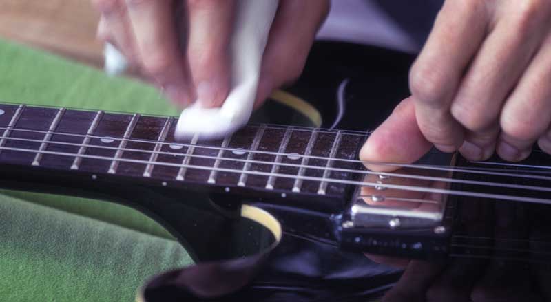 Close-up of a person cleaning guitar strings