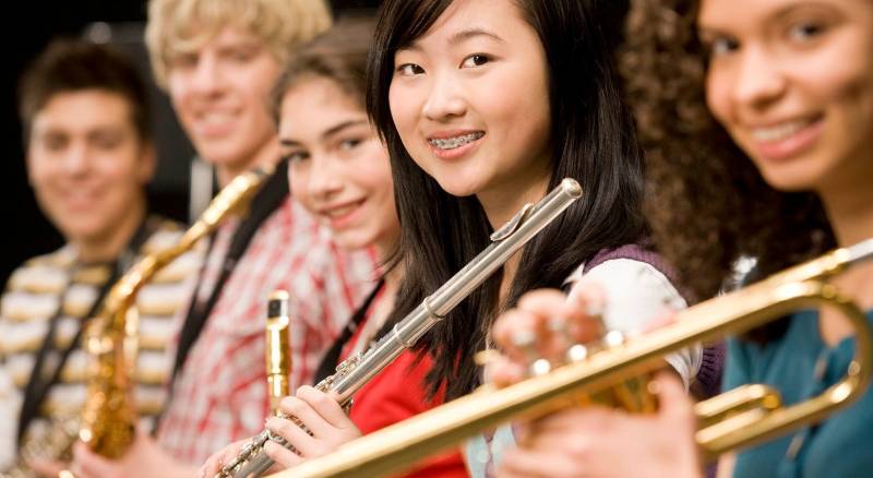 A group of student musicians playing instruments together demonstrates the unity of musical collaboration