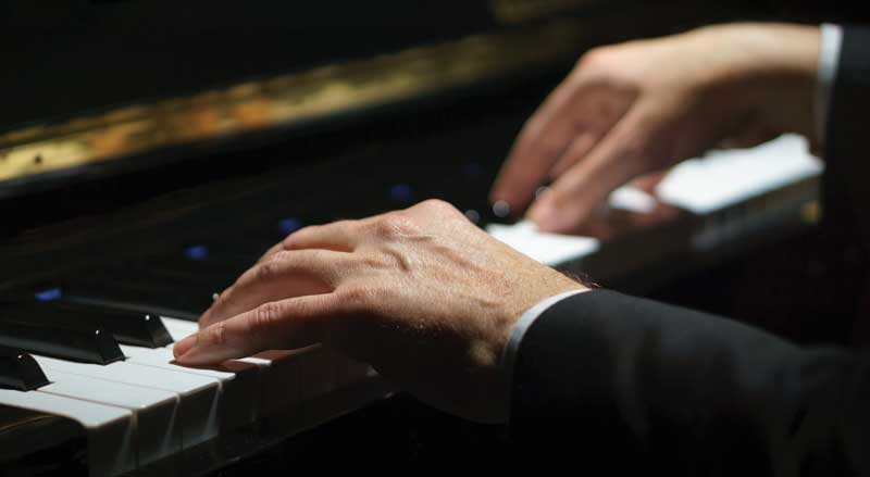 Man’s hands playing a piano