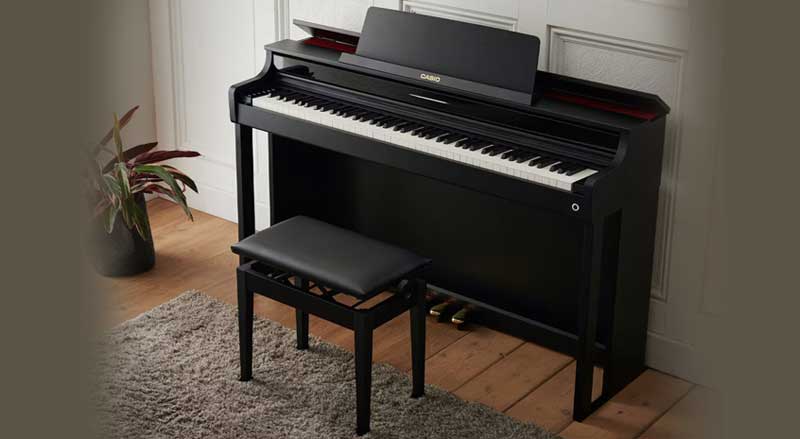 black Casio digital piano featured in traditional home with beige walls