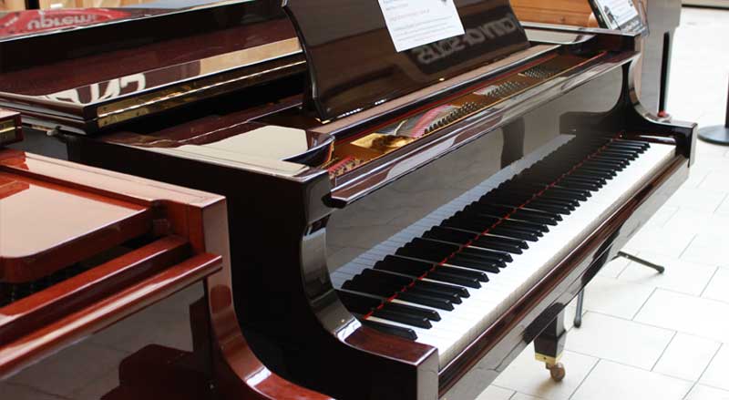 brown polished discount pianos for sale in showroom