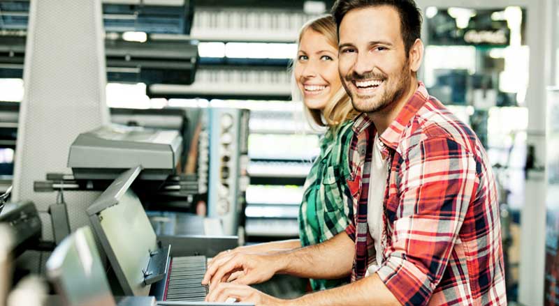 man and woman playing new pianos at music store