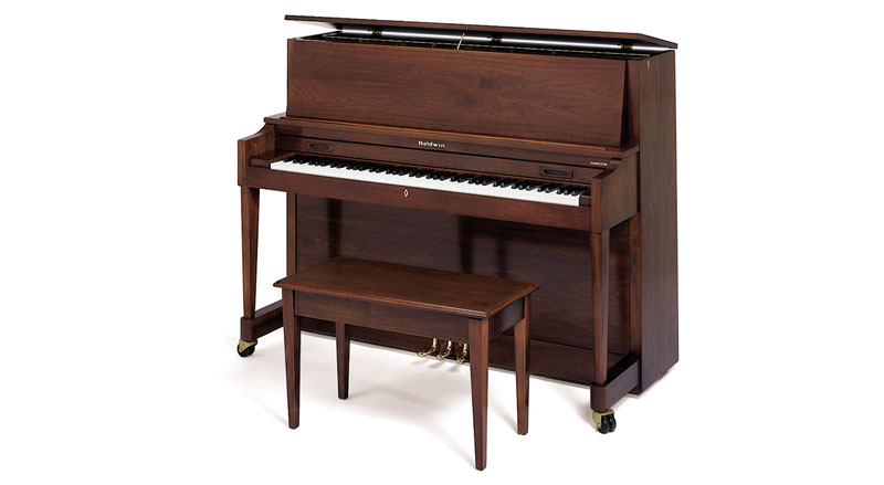 A Baldwin upright piano with a rich wood finish and matching bench, showcasing classic American craftsmanship.
